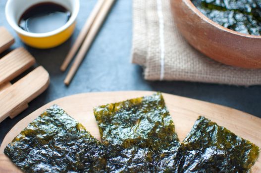 Close up of seaweed wafer snacks on a wooden board 