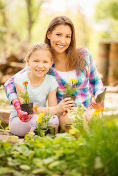 Beautiful mother and daughter planting flowers together.