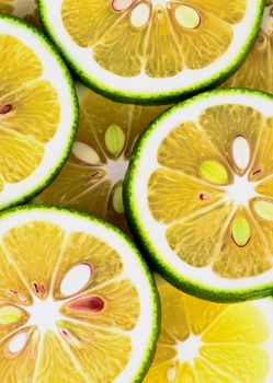 Fresh Ripe Sliced Green Lemons closeup as Background. Vertical View