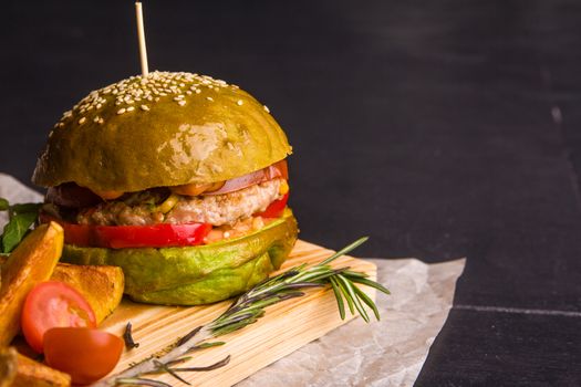 Concept: healthy food. Gourmet homemade burger with garnish and ingredients on the dark background.