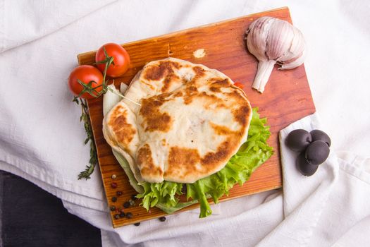 Concept: healthy food. Gourmet homemade burger with garnish and ingredients on the dark background.