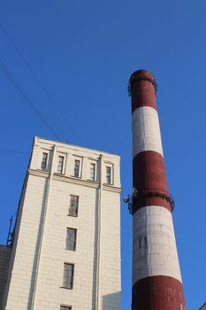 striped chimney power station on background blue sky