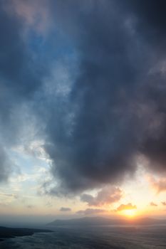 Dramatic sunset over Santorini caldera sea with volcano island