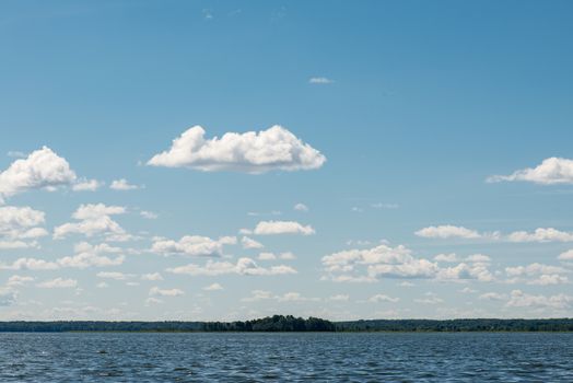 Beautiful summer lake, on  background of forest and cloudy sky.