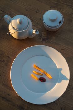 French fries with ketchup and on wooden table. Top view sunny evening.