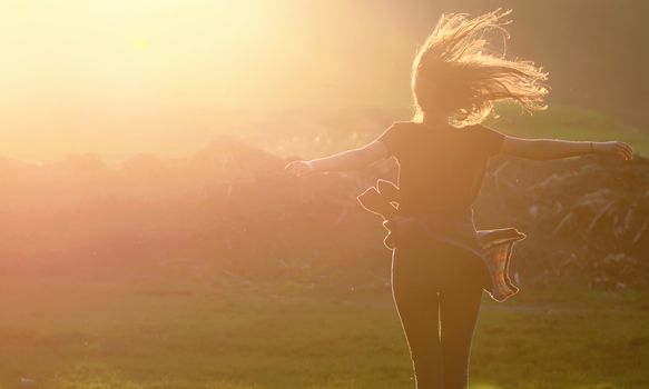 Girl  jumping up in a beautiful sunset setting