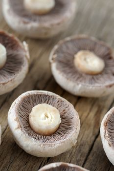Champignon mushrooms sliced on wooden table