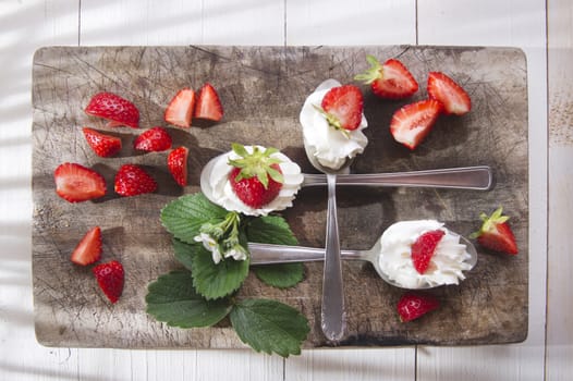 Presentation of the strawberries with cream spoons on various 