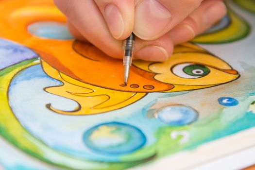 Close-up of the process of drawing goldfish