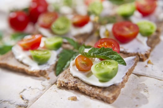 Presentation of slices of wholemeal bread with cheese and cherry tomatoes 