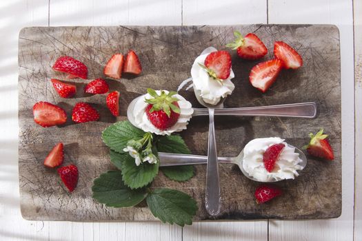 Presentation of the strawberries with cream spoons on various 