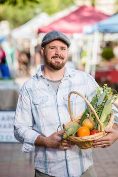 Bearded man with basket of produce at farmers market