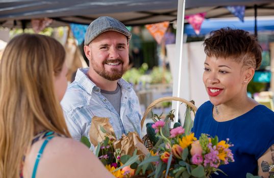 Attractive couple shopping for flowers at farmers market
