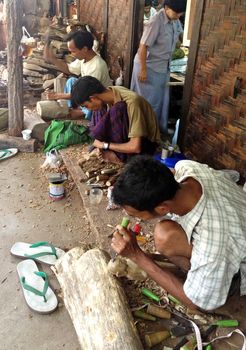 Mandalay, Myanmar, April 20, 2013 : Burmese Artisan works wood. Image take in a little village. A craftman is working on wood sculpture. Wood carving traditional is related with Myanmar culture.