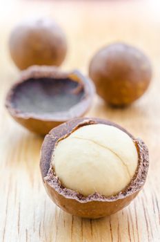 Close up the macadamia nuts on wooden background.