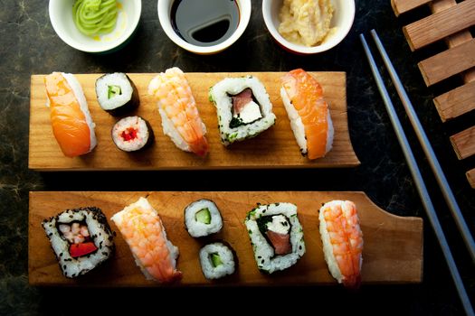 Selection of sushi including prawns, salmon and vegetables with rice on serving blocks 