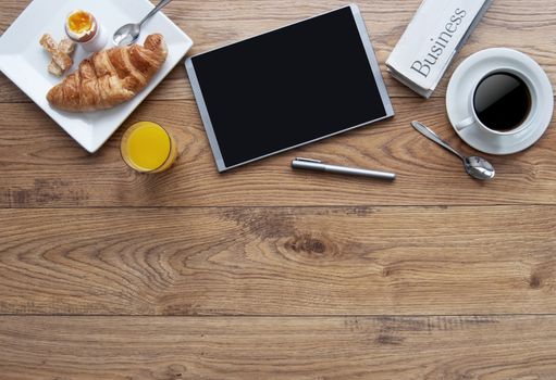Breakfast with digital tablet on a wooden background with space