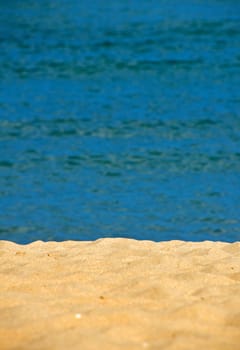 Tranquil idyllic sand beach resort shore over vivid blue sea wavy water background 