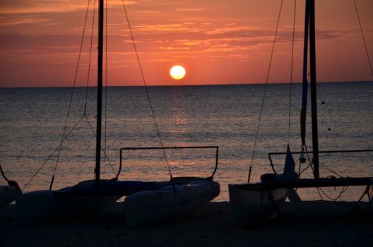 Sunset on the coast of Jamaica. Small boats on the shore.