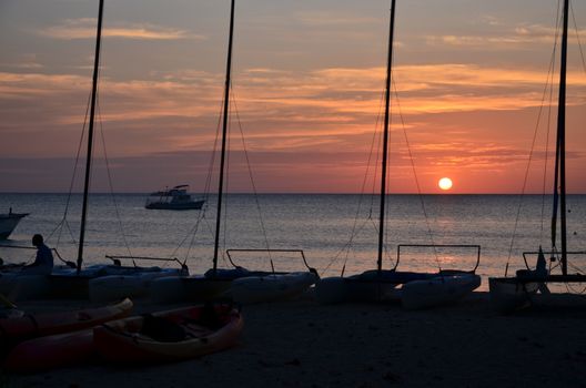Sunset on the coast of Jamaica. Small boats on the shore.