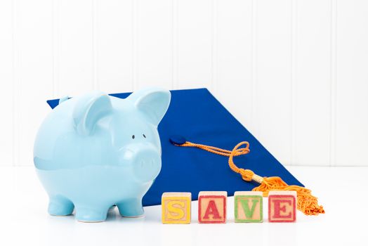 Blue piggy bank and graduation cap.  Conveys the concept of saving early for education.