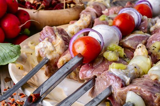 Raw pieces of beef threaded on skewers for kebabs