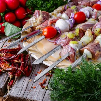 Raw pieces of beef threaded on skewers for kebabs