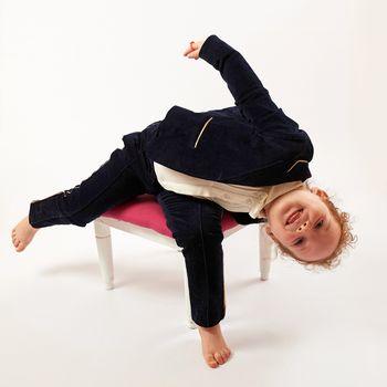 Little girl in black suit sitting and looks below