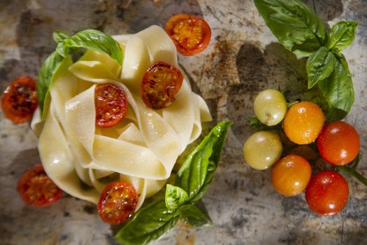 Nest of pappardelle pasta with tomato and basil 