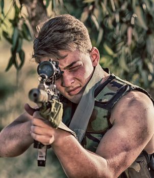 young a soldier in the uniform with weapon