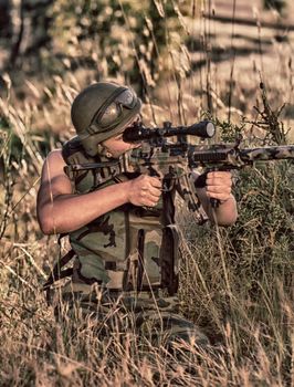 young a soldier in the uniform with weapon