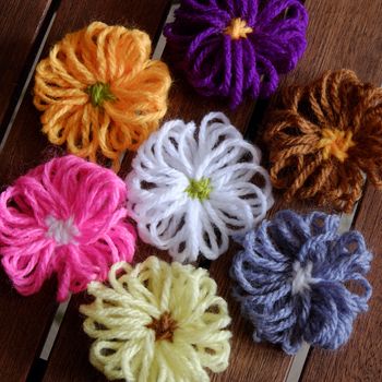 Group of handmade craft for mother day, colorful daisy flower on wood background, ornament make from yarn