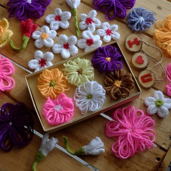 Group of handmade craft for mother day, colorful daisy flower on wood background, ornament make from yarn