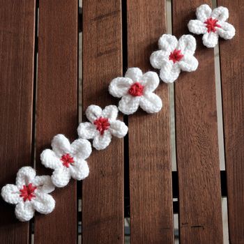 Group of handmade product for mother day, white daisy flower on wood background, make by knit from yarn