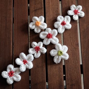 Group of handmade product for mother day, white daisy flower on wood background, make by knit from yarn