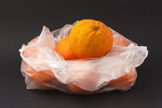 Oranges in a white envelope on a black background to understand a concept for healthy eating