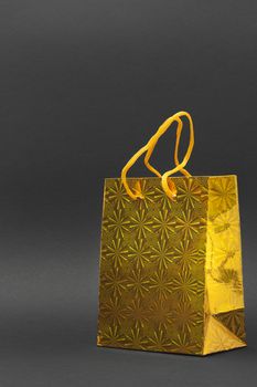 Shiny yellow gift bag isolated on a black background