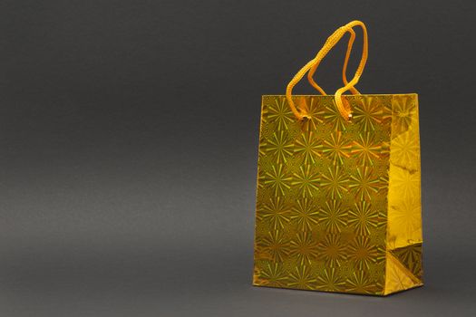 Shiny yellow gift bag isolated on a black background