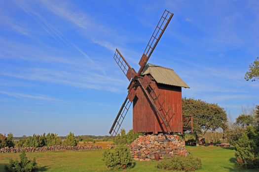 Old post windmill in Ohessare village. Post mill is the earliest type of european windmill.  Soft  evening sunlight. Windmills are typical tourist objects in Saaremaa villages.