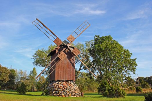 Old post windmill in Ohessare village. Post mill is the earliest type of european windmill.  Soft  evening sunlight. Windmills are typical tourist objects in Saaremaa villages.