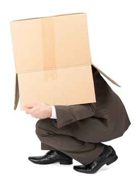 Businessman hiding behind box isolated on white background