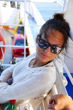 young caucasian brunette teenage girl wearing sunglasses travelling by ferryboat in Greece