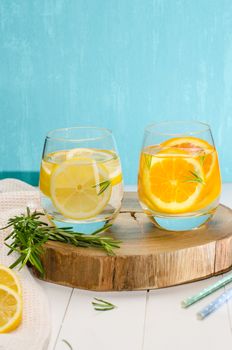 Detox fruit infused flavored water. Refreshing summer homemade cocktail with orange, lemon and rosemary leaves