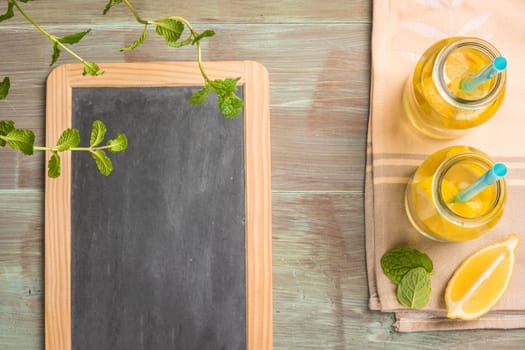 Glass of homemade lemonade with mint and lemon wedges. Top view with copy space.