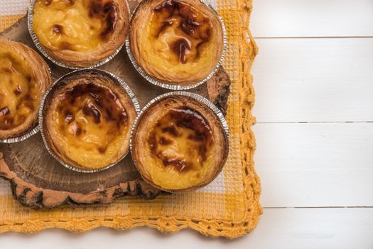 Pasteis de nata, typical Portuguese egg tart pastries on a set table. Top view with copy space