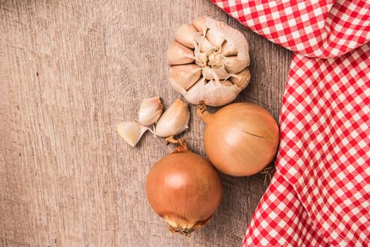 Fresh vegetables from the garden, garlic and onions on a wooden table.