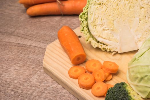 Fresh vegetables from the garden, carrots, cabbage, broccoli, onion and garlic on a wooden table. Vegetables for preparing soup