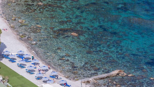 Aeral view of sicilian beach with peopAeral view of sicilian beach with people, umbrellas and wonderful sea.