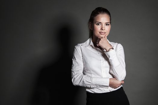 Portrait of young businesswoman on dark background