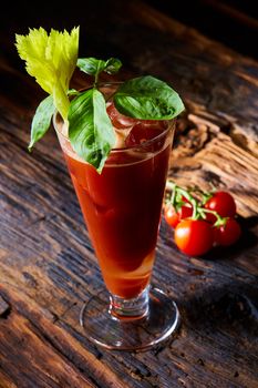 Cocktail Bloody Mary with ice in glasses on a wooden table